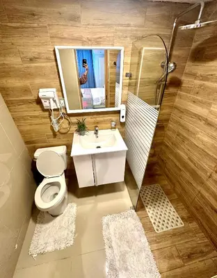 a bathroom with a toilet and a sink and a mirror at Noe Hotel , One Bed Room Close to The beach Room #1 in Punta Cana