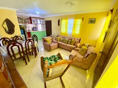 a living room with a couch and a table at Hospedaje Villa Valencia en Los Patos in Los Patos