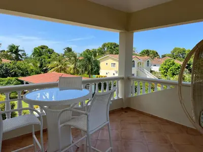 a balcony with a table and chairs and a view at Villa 102A, 5 master bedroom and 5 full bathrooms with private pool in Sosúa