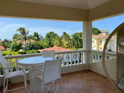a balcony with a table and chairs and a view at Villa 102A, 5 master bedroom and 5 full bathrooms with private pool in Sosúa