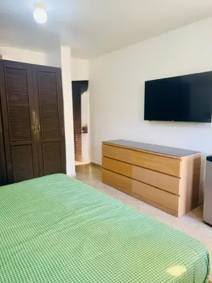a bedroom with a bed and a flat screen tv at Hispaniola 3 bed, 3 bath Villa with pool & jacuzzi in Sosúa