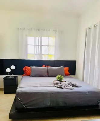 a bedroom with a large bed with orange pillows at Hispaniola 3 bed, 3 bath Villa with pool & jacuzzi in Sosúa