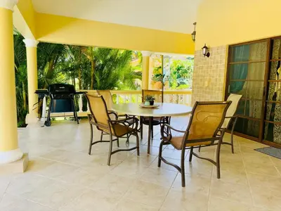 a dining room with a table and chairs and a piano at Hispaniola 3 bed, 3 bath Villa with pool & jacuzzi in Sosúa