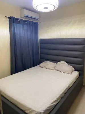 a bed with a blue headboard and two pillows on it at Lesnah Apartamento, Jacobo Majluta in Los Casabes
