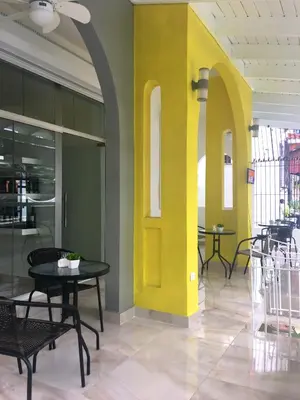 a yellow door in a room with tables and chairs at Hotel Unico in Santo Domingo