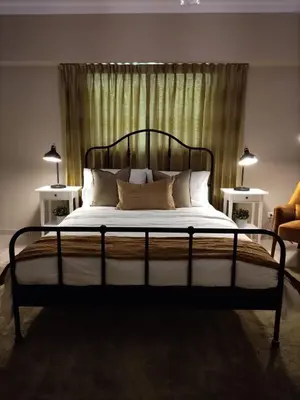 a bedroom with a large bed with two lamps at Cómodo y Equipado Apt Cerca del Malecón in Santo Domingo