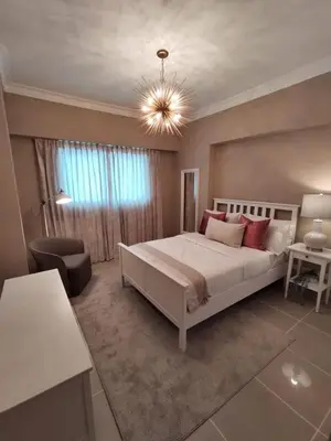 a bedroom with a large white bed with red pillows at Cómodo y Equipado Apt Cerca del Malecón in Santo Domingo