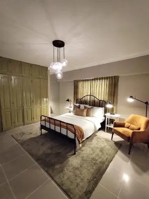 a bedroom with a large bed and a chair at Cómodo y Equipado Apt Cerca del Malecón in Santo Domingo