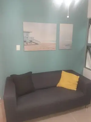 a black couch with a yellow pillow in a living room at Comodas 3 Habitaciones, Wifi 1er piso in Santiago de los Caballeros