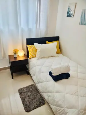 a bedroom with a large white bed with a side table at Comodas 3 Habitaciones, Wifi 1er piso in Santiago de los Caballeros
