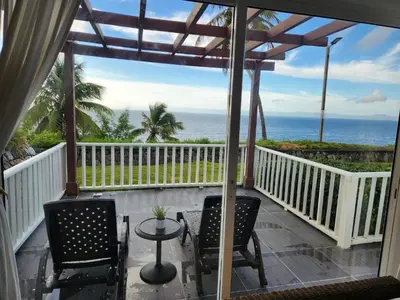 a balcony with two chairs and a table and the ocean at Perfect Paradise, Oceanview in Samana in Santa Bárbara de Samaná