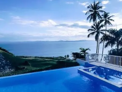 a large swimming pool with a view of the ocean at Perfect Paradise, Oceanview in Samana in Santa Bárbara de Samaná