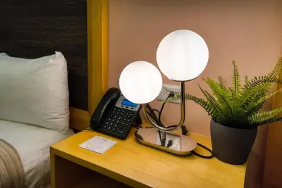 a hotel room with a phone and a lamp on a table at Melina Hotel in Higuey