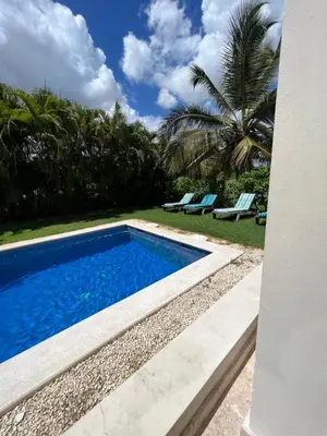 a swimming pool next to a yard with palm trees at Private Villa LaPerla Iberosta 3BDR, Pool, Beach, WiFi in Punta Cana