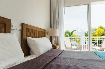 a bedroom with a bed with a view of a balcony at Private Villa LaPerla Iberosta 3BDR, Pool, Beach, WiFi in Punta Cana