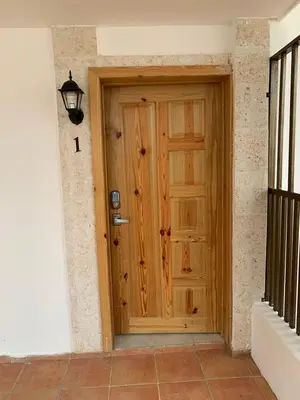 a wooden door in the corner of a building at Noé Hotel ,1 Bedroom # 5 near to the beach in Punta Cana