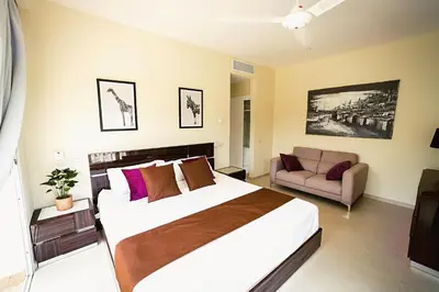 a bedroom with a large bed and a couch at Private Iberosta Villa Fortuna - 4BDR, Pool & Private Beach in Punta Cana