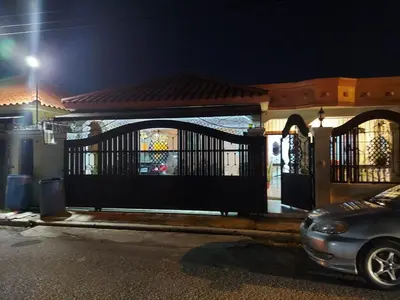 a car parked in front of a gate at night at Hermosa casa urbanización Jardines del Norte in Santiago de los Caballeros