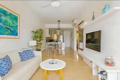 a living room with a white couch and a table at Cana Rock Condos Familiar - Two apartments very close-Ground floor direct access to the pool in Punta Cana
