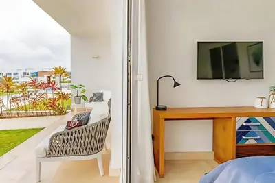 a bedroom with a desk and a tv and a chair at Cana Rock Condos Familiar - Two apartments very close-Ground floor direct access to the pool in Punta Cana