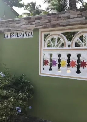 a sign on the side of a house with a window at Villa La Esperanza in Nizao