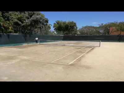 a person is standing on a tennis court at Delightful Caribbean apartment in Boca Chica in Boca Chica