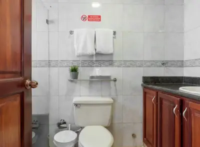a bathroom with a white toilet and a sink at Escape 3BR Apartment in the Heart of Piantini Nightlife in Santo Domingo
