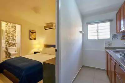 a small bedroom with a bed and a bathroom at Studio in Los Jardines Sleeps 2 in Santo Domingo