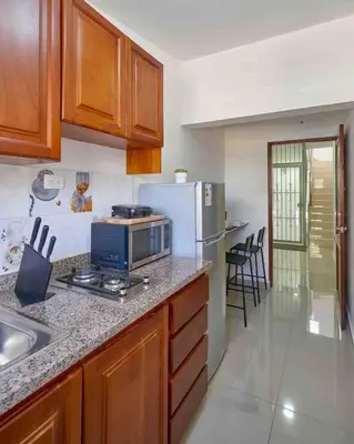 a kitchen with a counter with a microwave and a refrigerator at Studio in Los Jardines Sleeps 2 in Santo Domingo
