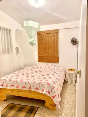 a bedroom with a bed and a window and a table at Local vacation beach house in Santa Cruz de Barahona