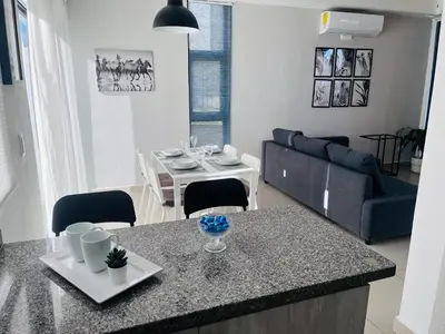 a kitchen and living room with a table and a couch at Townhouse with Private Pool and nearby beaches in Punta Cana