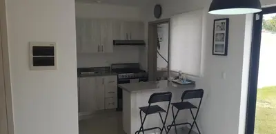 a kitchen with a counter and two bar stools at Townhouse with Private Pool and nearby beaches in Punta Cana
