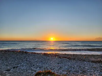 a sunset over the ocean with a rocky beach at Beachfront Apartment, Quiet 4 Beds, 1 Bath, AC, Wi-Fi, Hot Water, in Paraiso near Los Patos in Paraíso