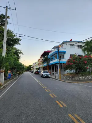 a street with buildings and a car parked on the street at Beachfront Apartment, Quiet 4 Beds, 1 Bath, AC, Wi-Fi, Hot Water, in Paraiso near Los Patos in Paraíso