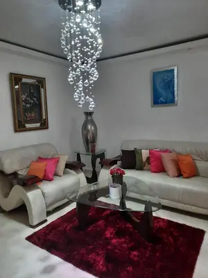 a living room with two couches and a chandelier at Caribean Dreams Apartement Beautiful Pool and Gym in Santiago de los Caballeros