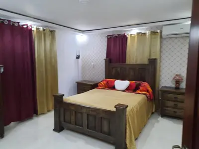 a bedroom with a bed in a room with curtains at Caribean Dreams Apartement Beautiful Pool and Gym in Santiago de los Caballeros