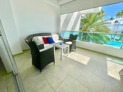 a living room with a couch and a table and a window at Marbella 2bedroom Beachfront Apartment in San Pedro de Macorís