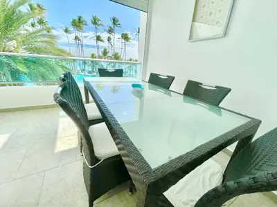 a dining room with a glass table and chairs at Marbella 2bedroom Beachfront Apartment in San Pedro de Macorís