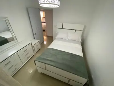 a small bedroom with a bed and a mirror at Dr Adorable Y Comfortable Apt para Su Disfrute in Santiago de los Caballeros