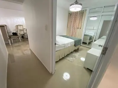 a small room with a bed and a mirror at Dr Adorable Y Comfortable Apt para Su Disfrute in Santiago de los Caballeros