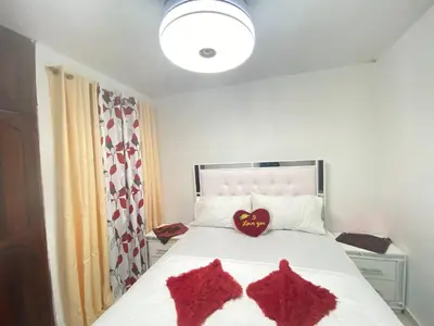 a bedroom with two red knitted mittens on a bed at 9DR 3-Bedroom Apartment Near Monumental Area in Santiago de los Caballeros