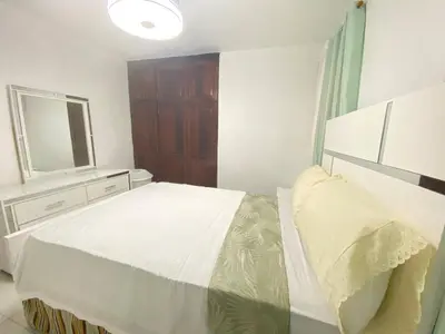 a bedroom with a large bed and a mirror at 9DR 3-Bedroom Apartment Near Monumental Area in Santiago de los Caballeros