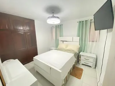 a bedroom with two beds and a flat screen tv at 9DR 3-Bedroom Apartment Near Monumental Area in Santiago de los Caballeros
