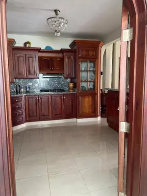 a kitchen with wooden cabinets and a tile floor at Maria's Entire House HIGUEY 2BD in Higuey