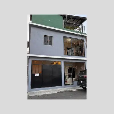 a building with a car parked in front of it at Lovely tiny studio in Jarabacoa