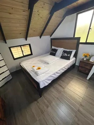 a bedroom with a large bed with white sheets and pillows at Lovely tiny studio in Jarabacoa