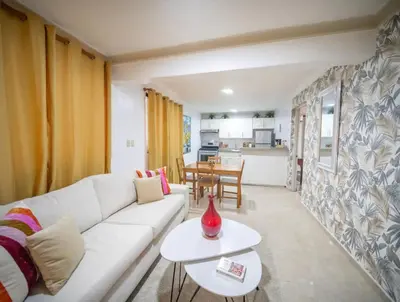 a living room with a white couch and a table at Stylish 1r-1b Apt Near The Beach And Main Street in Sosúa