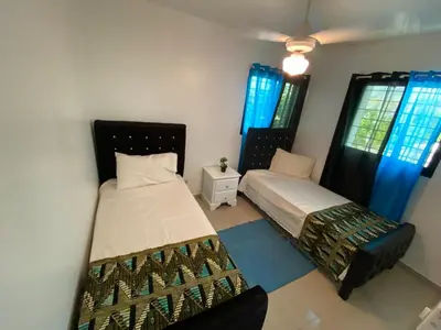two beds in a room with blue curtains at Santiago Center Huge Apartment 2stay rooftop to enjoy the city view 6-3 in Santiago de los Caballeros