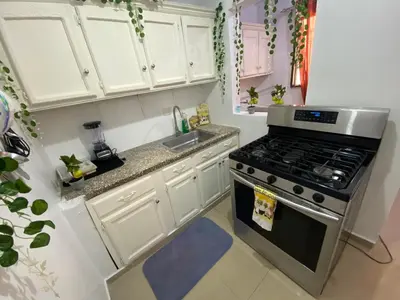 a kitchen with white cabinets and a stove top oven at 8 Santiago Monumental Area Cozy and lovely to enjoy 3 bedrooms Apart transportation 24 hours in Santiago de los Caballeros