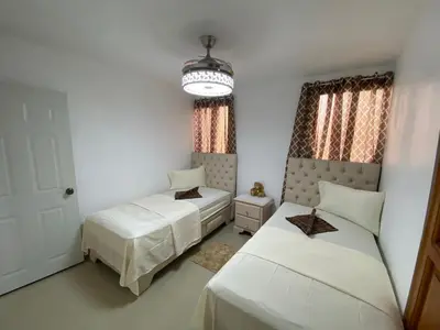 a bedroom with two beds and a chandelier at 8 Santiago Monumental Area Cozy and lovely to enjoy 3 bedrooms Apart transportation 24 hours in Santiago de los Caballeros